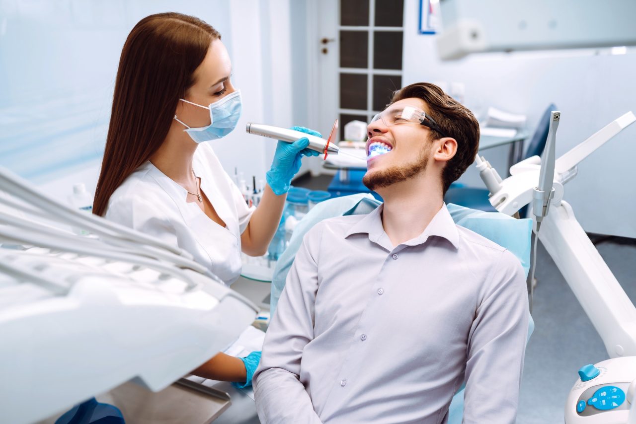 young man at the dentist s chair during a dental procedure overview of dental caries prevention 1 1