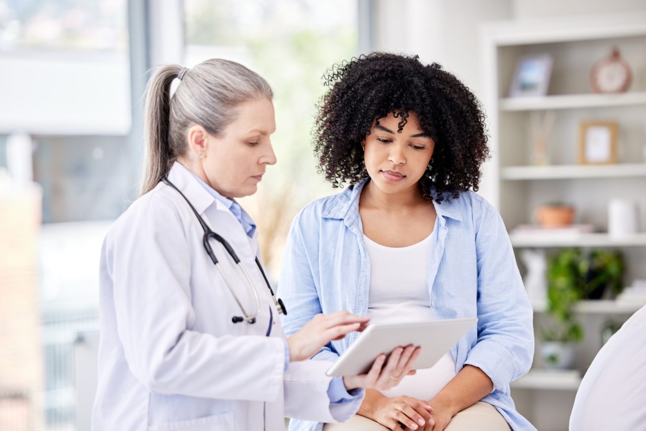 youre as fit as a fiddle shot of a dentist and a patient using a tablet in a office