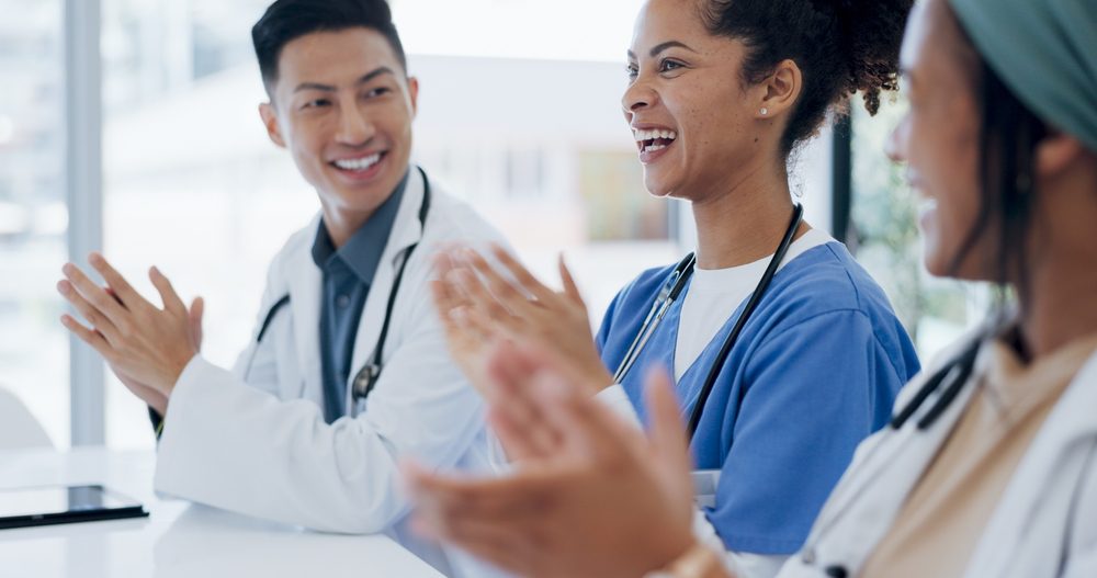 Medical team examining digital records together with registry management software during a clinical workflow meeting.
