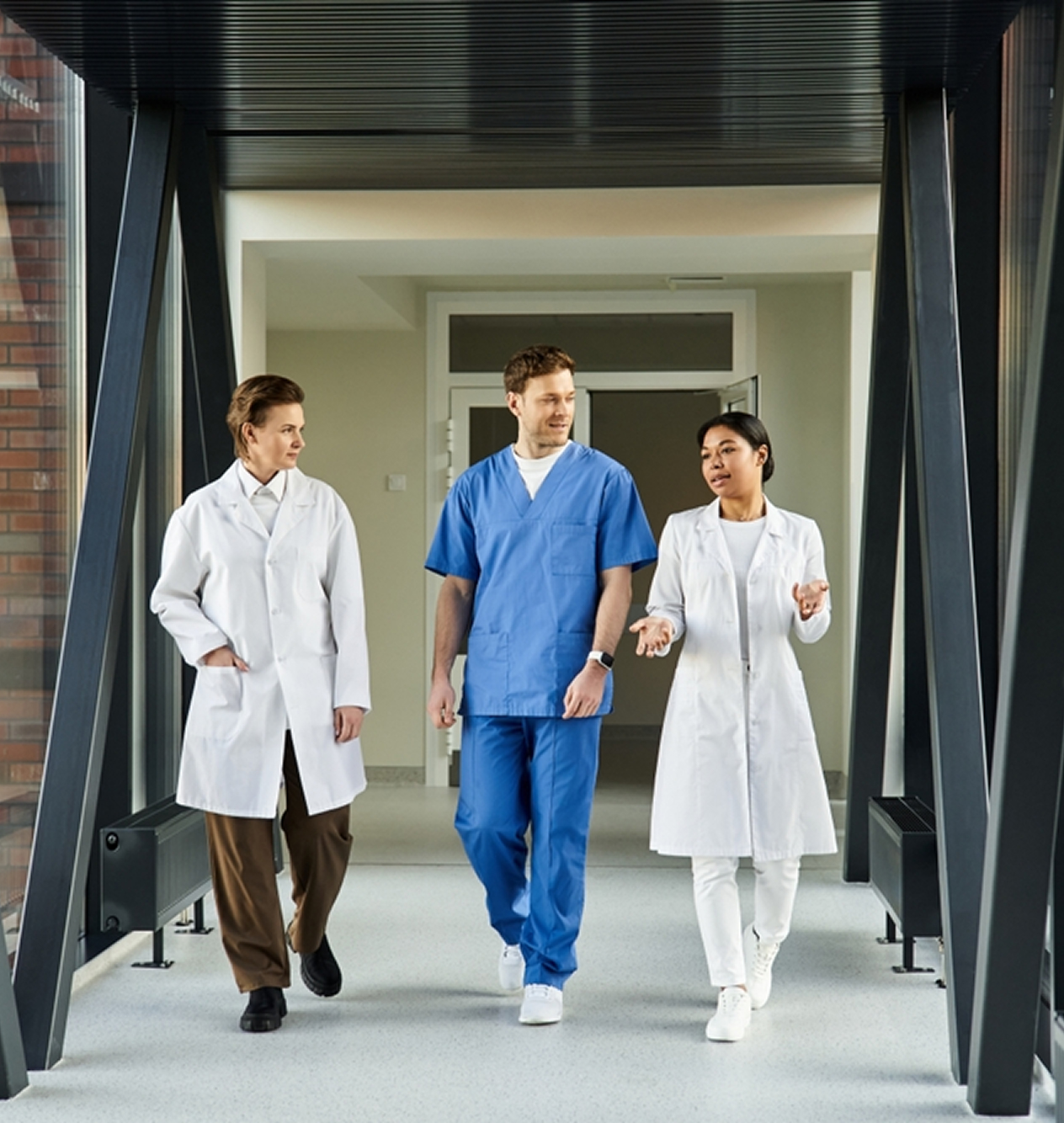 two healthcare professionals reviewing clinical data abstraction services documentation in hospital hallway